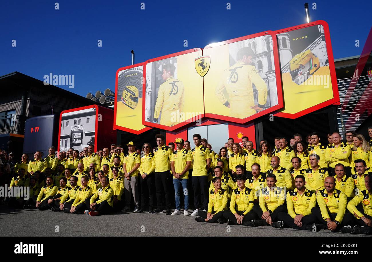 The Ferrari team pose for a photograph in their yellow uniforms as team celebrate their 75th anniversary before the Italian Grand Prix at the Monza circuit in Italy. Picture date: Sunday September 11, 2022. Stock Photo