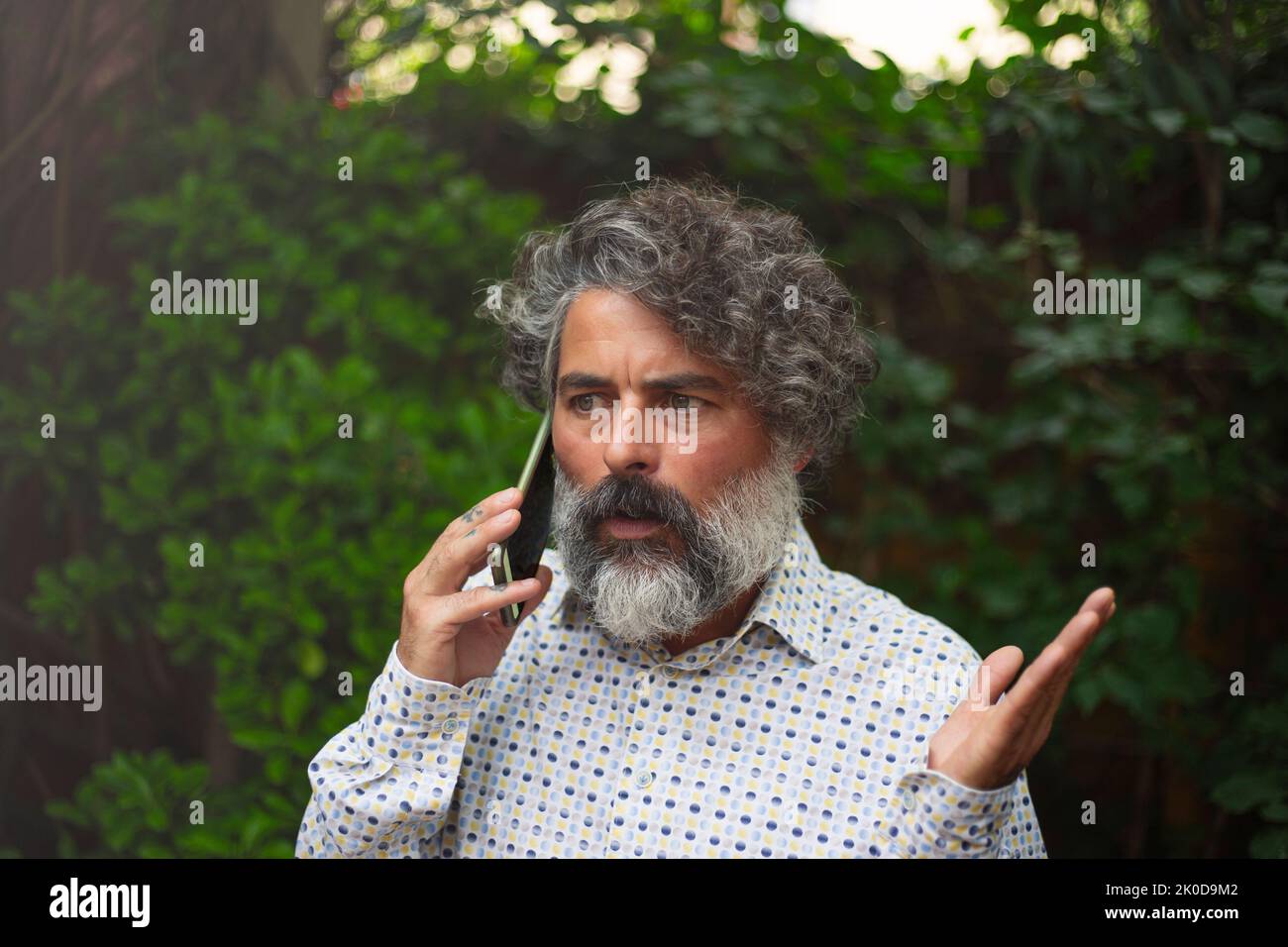 Hipster businessman talking with a worried face on his cell phone Stock Photo