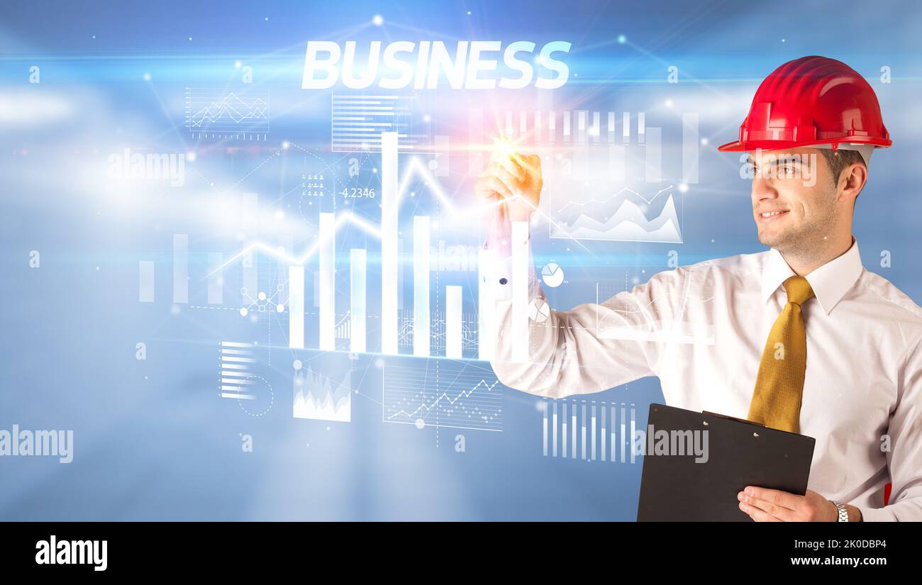 Young businessman with helmet drawing on virutal screen Stock Photo