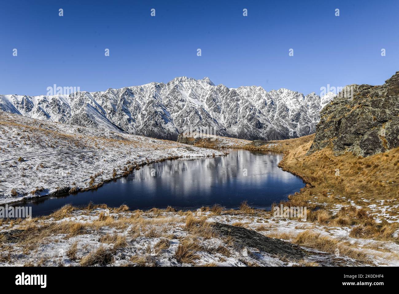 The Remarkables reflected in Summit Tarn Deer Park Heights near Queenstown South Island New Zealand Stock Photo