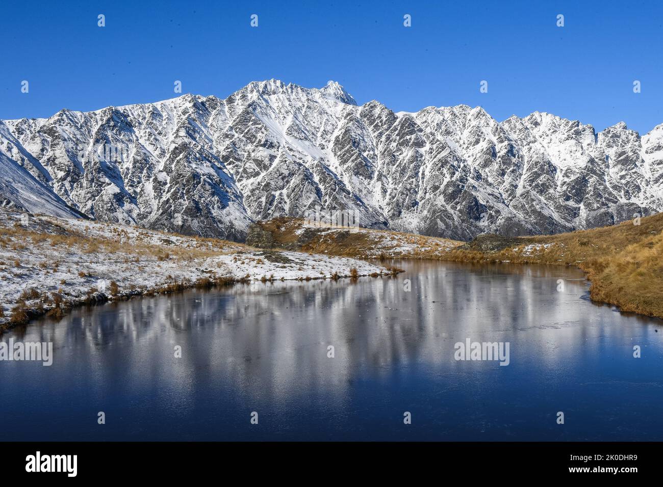 The Remarkables reflected in Summit Tarn Deer Park Heights near Queenstown South Island New Zealand Stock Photo