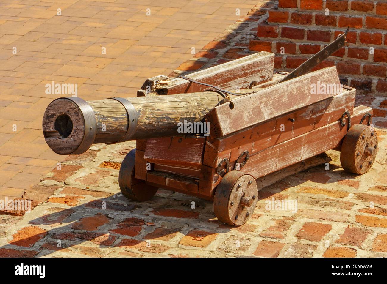 Old cannon over stone wall. Old castle. Ancient cannon on wheels. Stock Photo