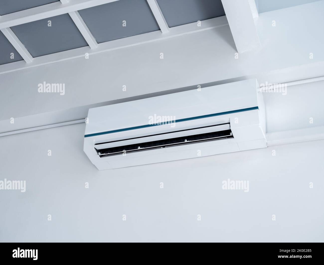 White air conditioner on wall background. Wall mounted air conditioner hanging on white wall under the room structure in clean living room in the hous Stock Photo