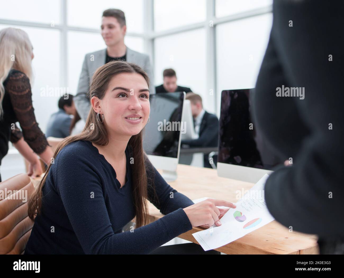 smiling young business woman sitting at an office Desk Stock Photo - Alamy