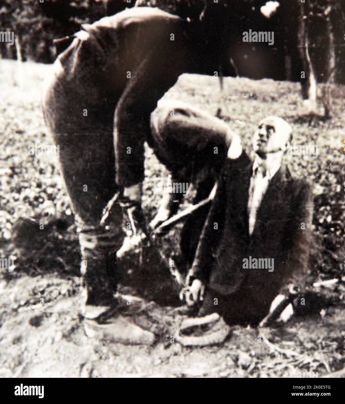 Two Polish Jews are forced to dig their own graves. 1941. This was a common practice throughout the Holocaust. Not only did this reduce the work of the Nazi murderers, but it also had the effect of further denigrating the victims as they went to their deaths. Stock Photo