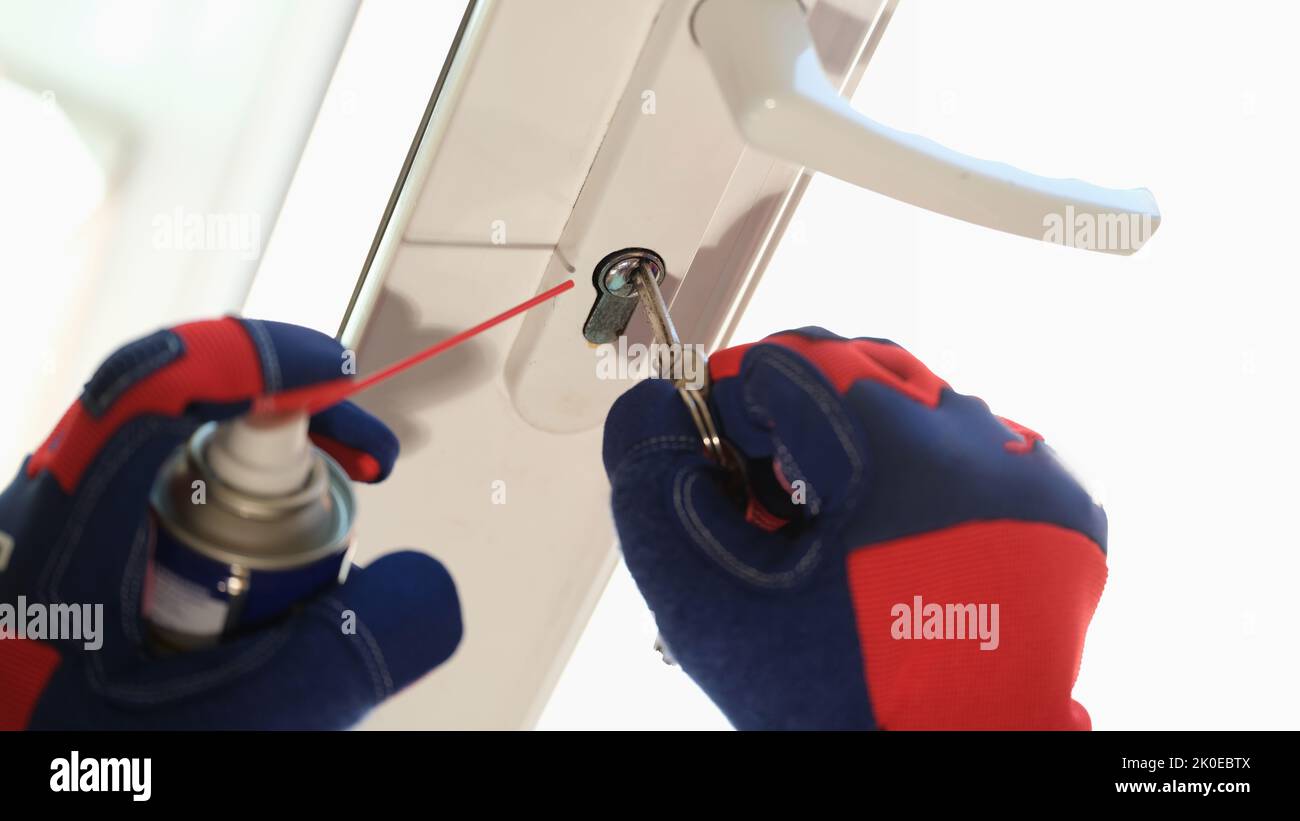 Window foreman repairs a rusty old lock with key on window frame Stock