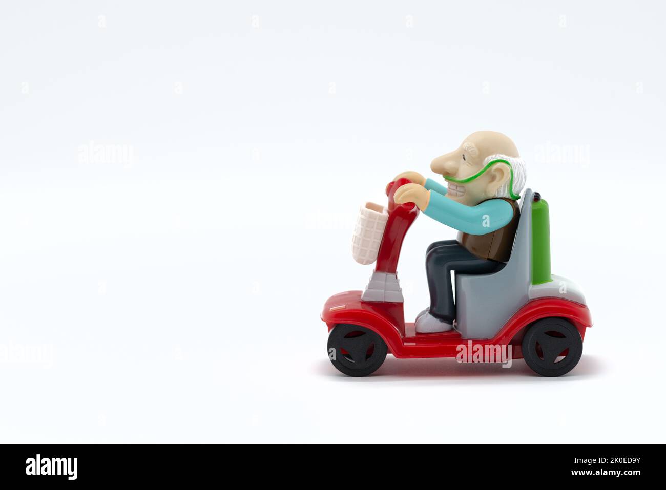 Grandfather on motorized wheelchair, toys, white background, cropped image Stock Photo