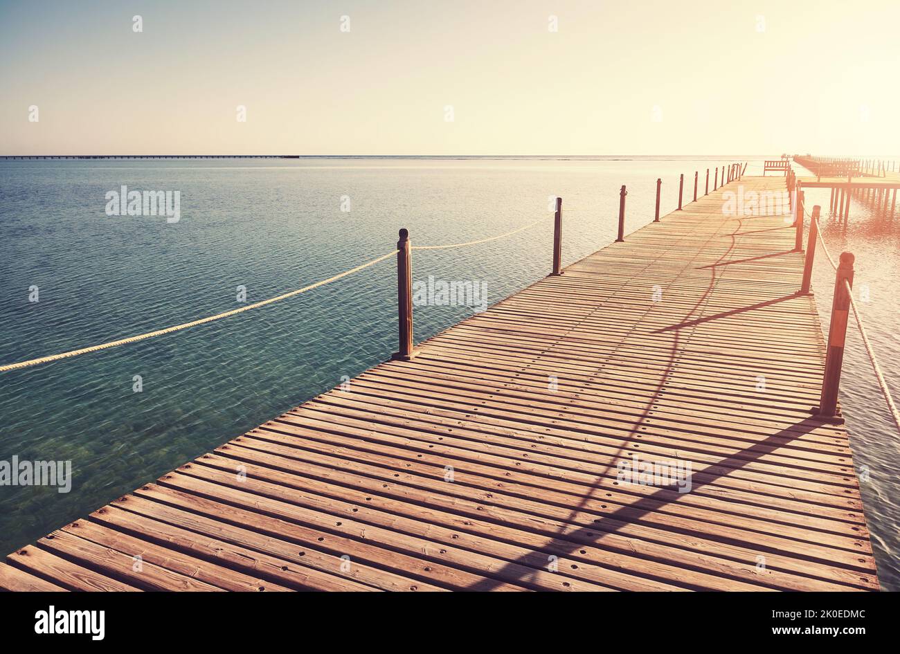 Wooden pier at sunrise, color toning applied. Stock Photo