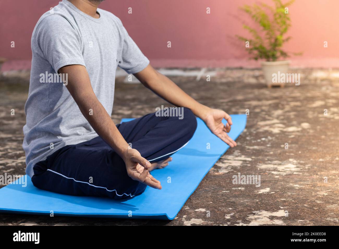 An Indian girl child practicing yoga on yoga mat outdoors Stock