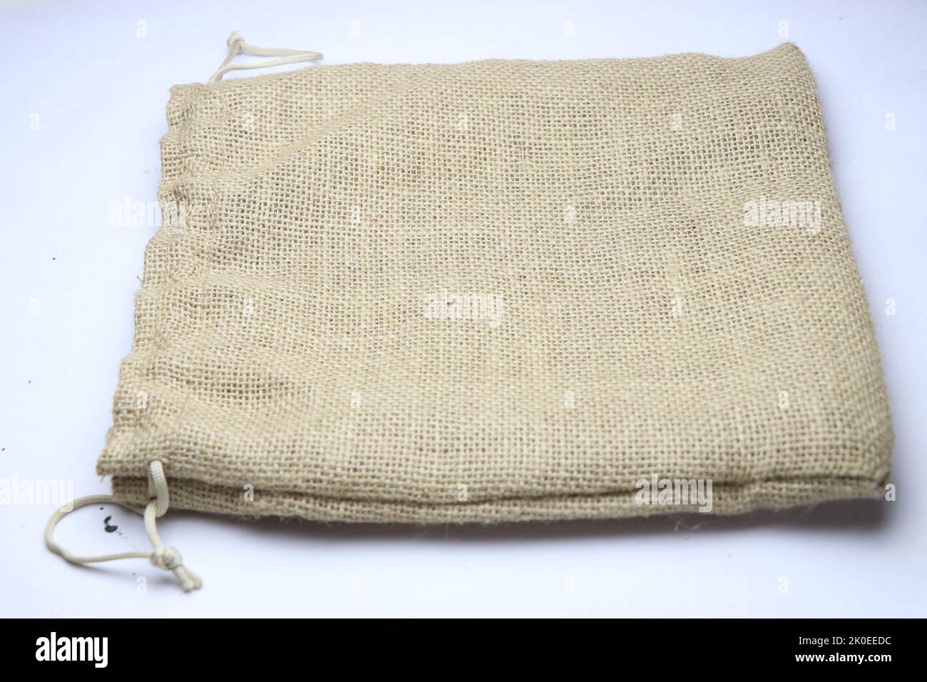 A small jute bag made from natural fibers and completely environment-friendly used for packing gifts kept on a white background Stock Photo