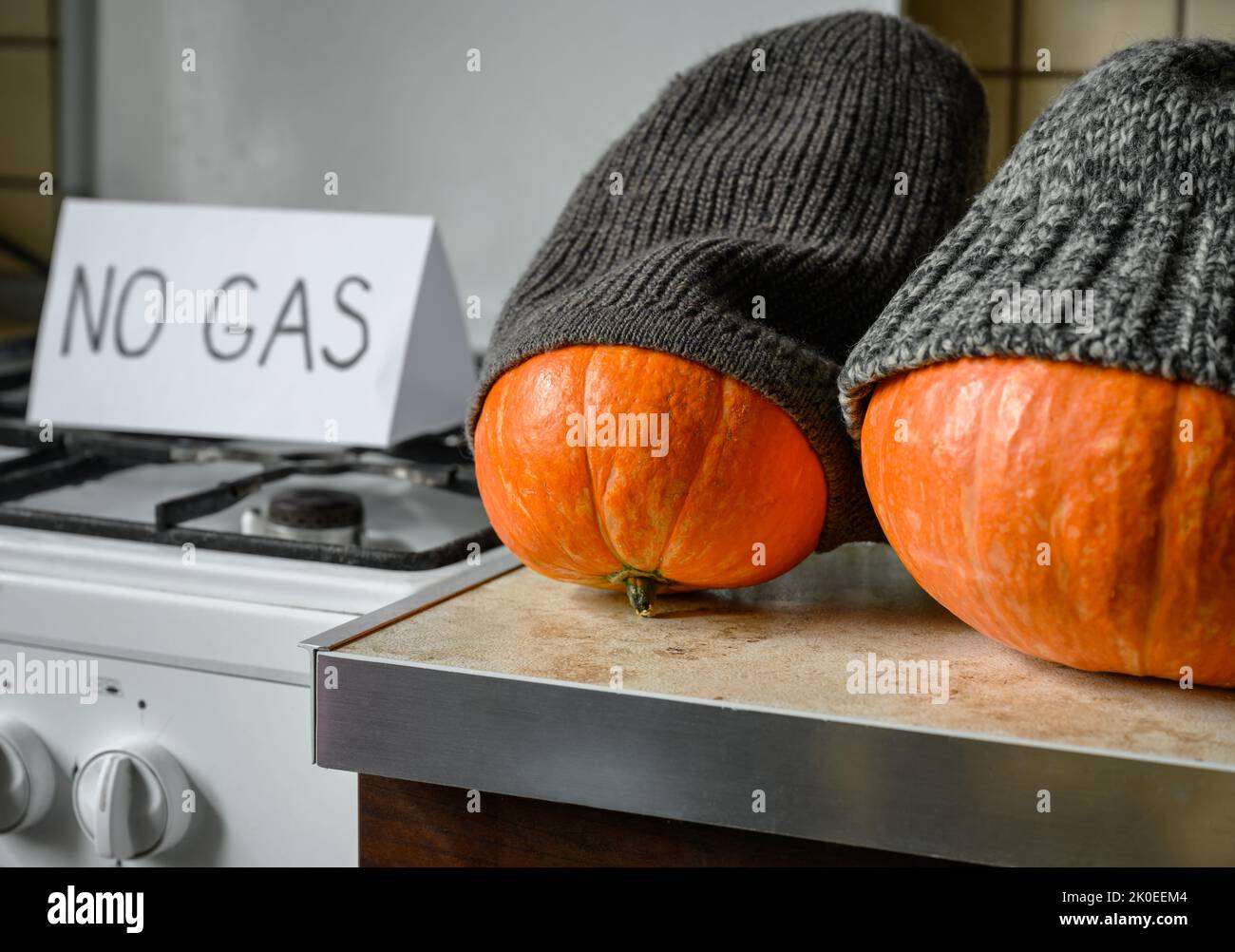 Pumpkins in winter knit hats on Halloween at cold home, expensive gas and electricity for heating, funny vegetables are freeze. Energy crisis, thanksg Stock Photo