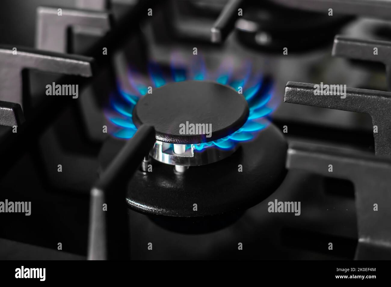 The gas burner of the black stove burns with a blue flame. Production