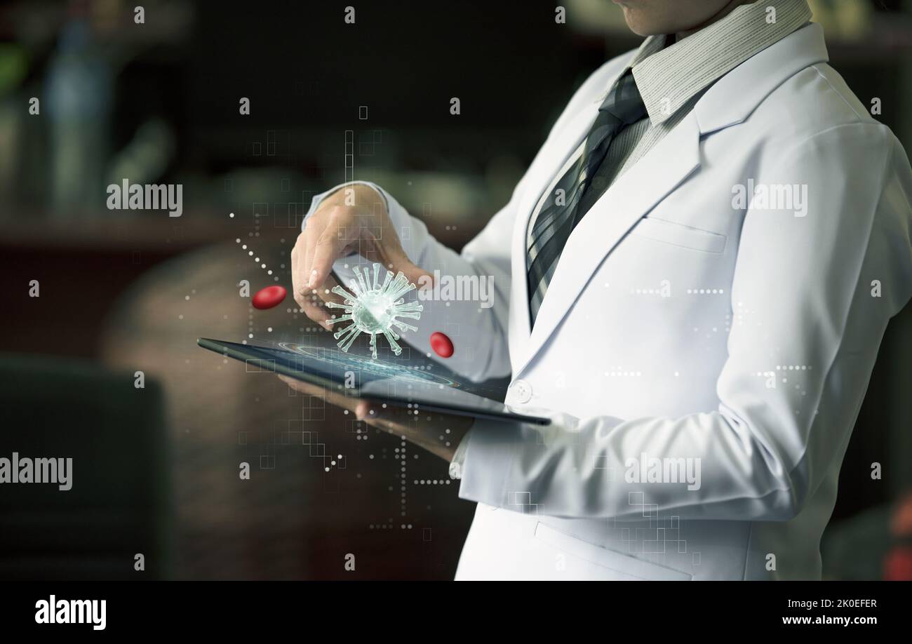 Woman doctor holding hand on device with holographic virus and red blood cell Stock Photo