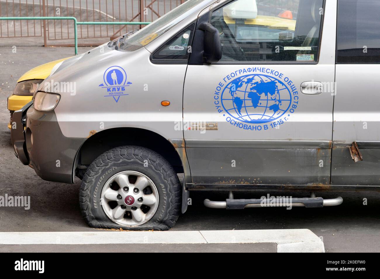 The logo of the Russian Geographical Society and the My Planet TV channel on an old abandoned car. Auto junk. Stock Photo