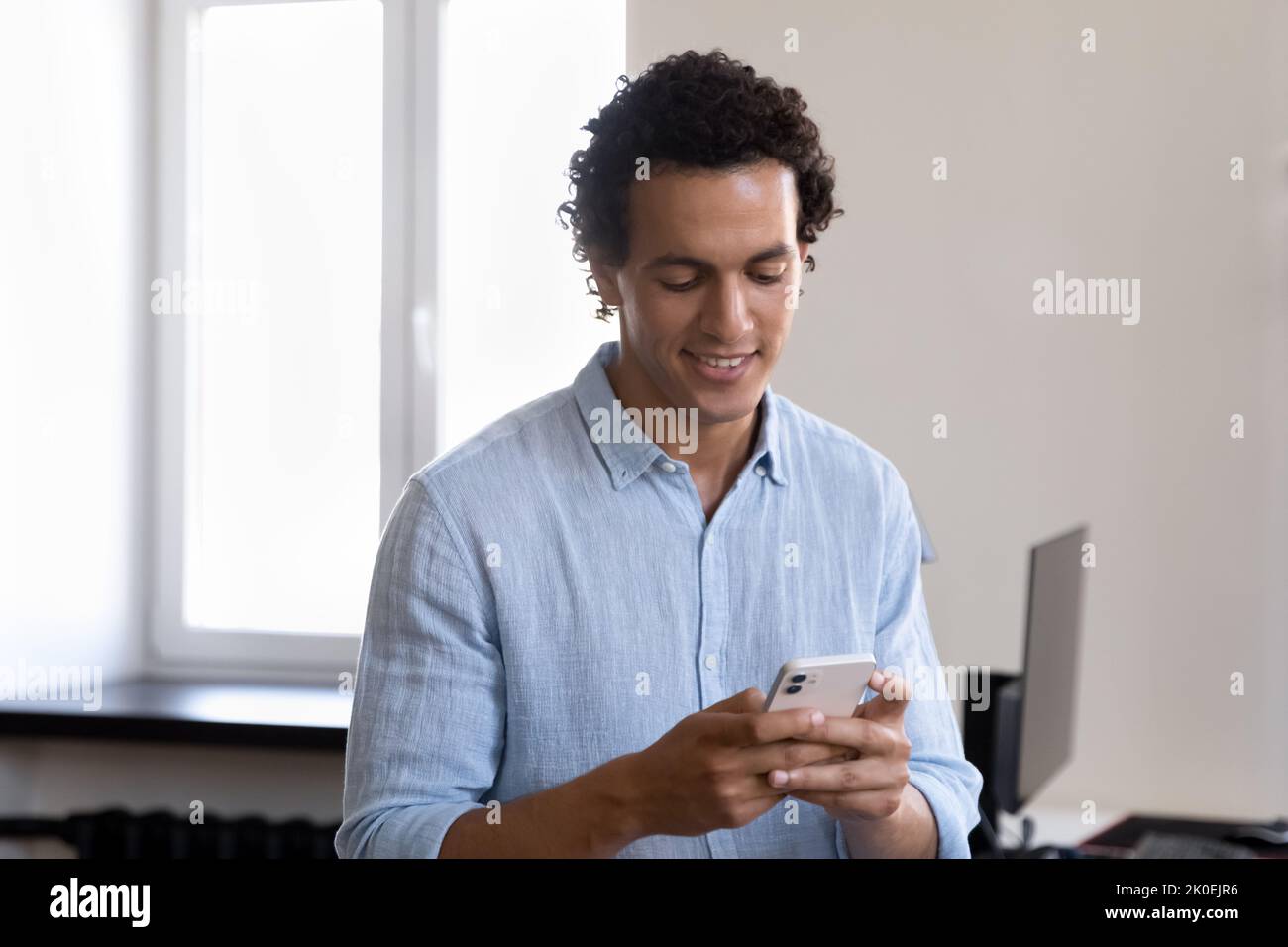 Man Using Online Program Happy Latin office employee man using online app on smartphone Stock ...