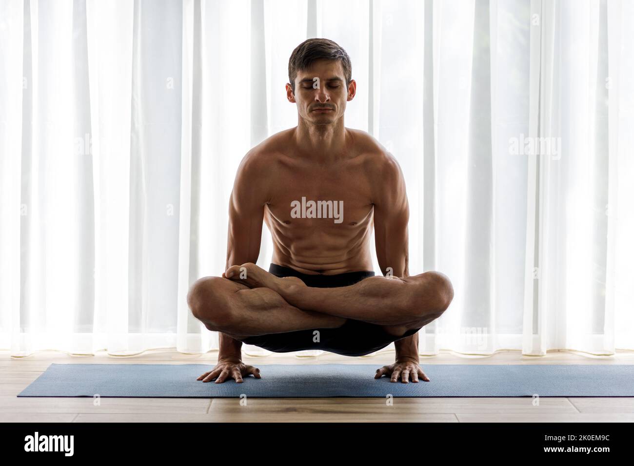 Middle-aged man doing his morning yoga routine standing on hands in ...