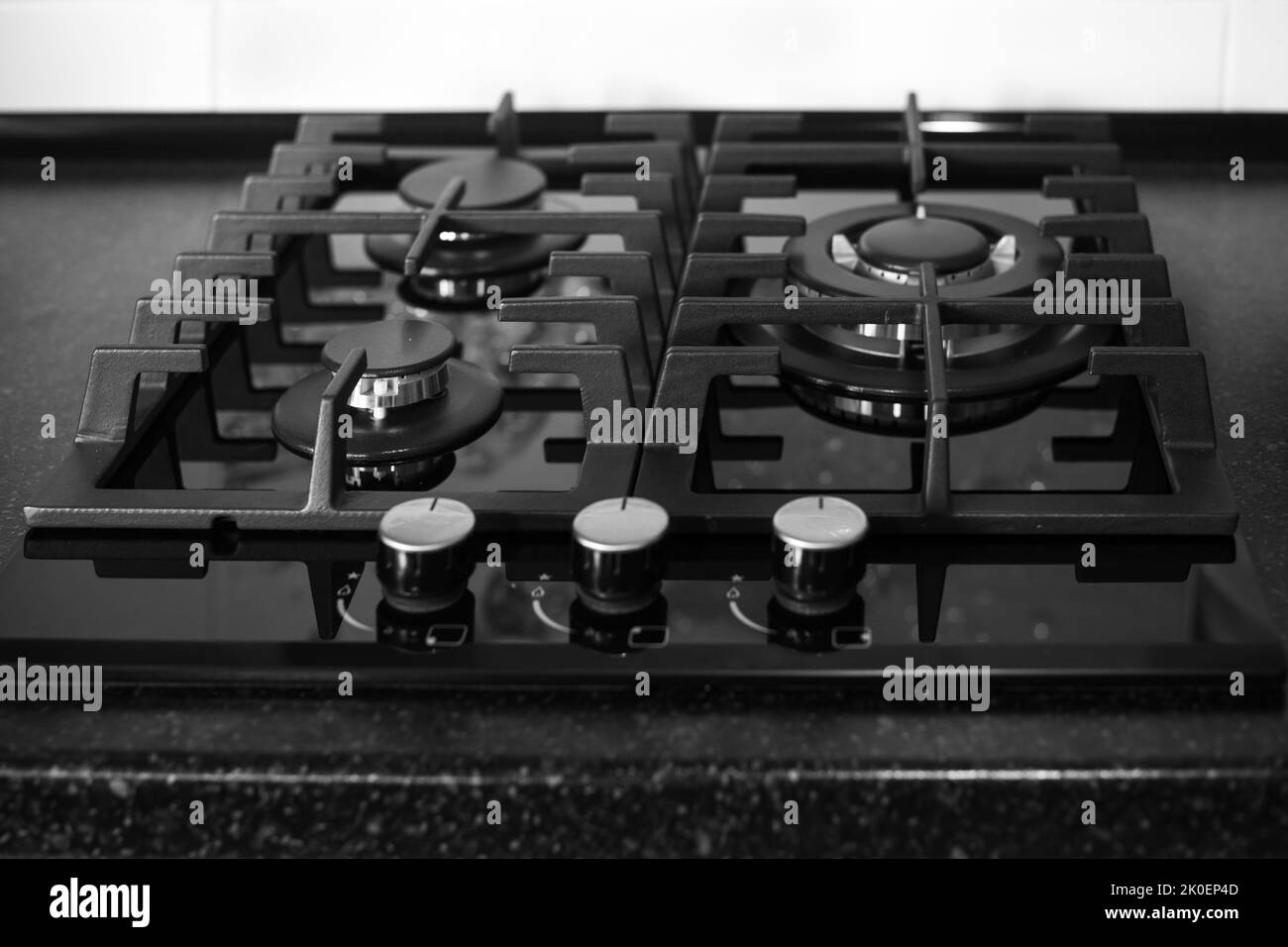 Black builtin gas stove on a black countertop. Kitchen interier Stock