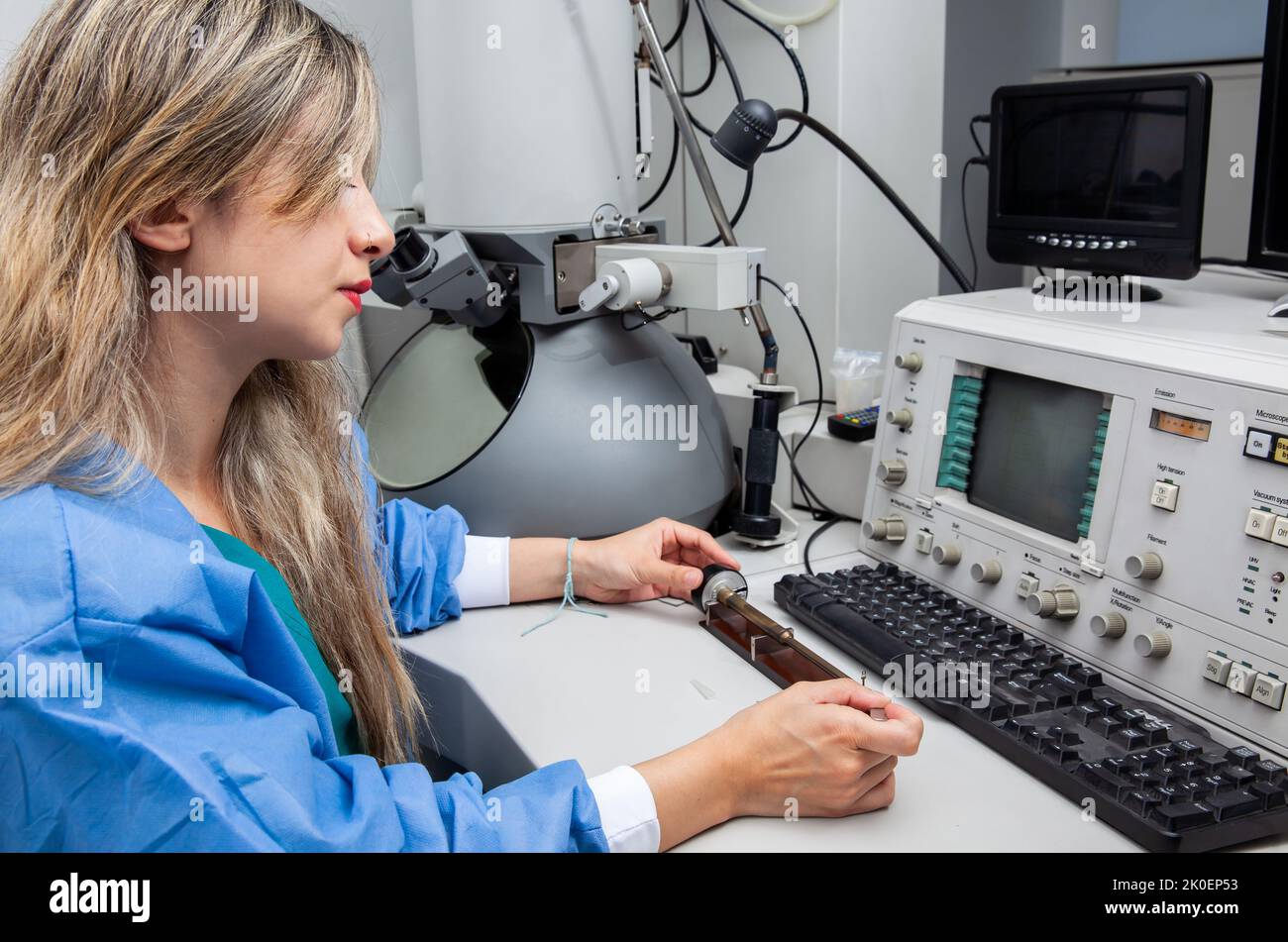 Young female scientist loading a grid with an specimen on the sample