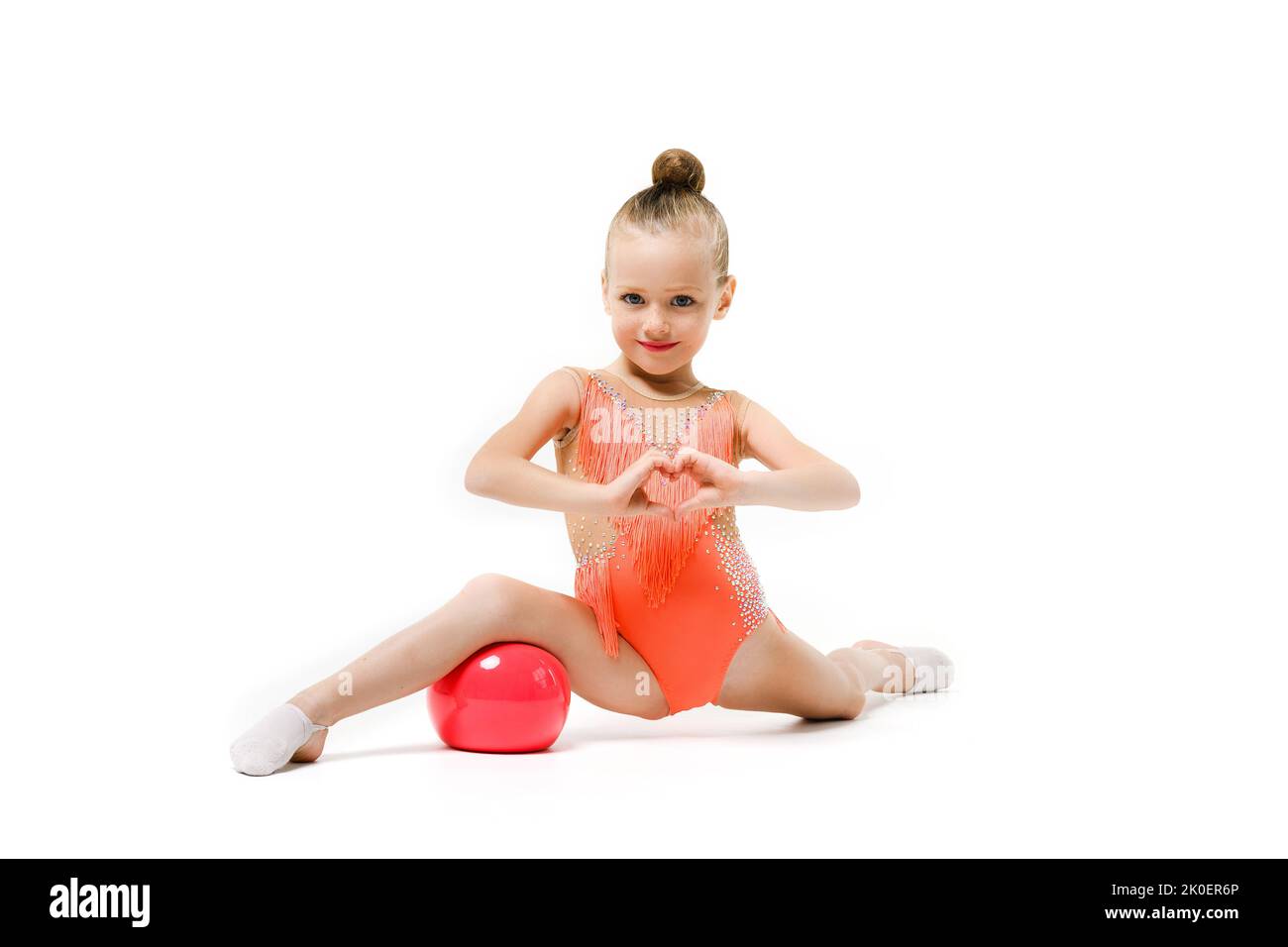 Little girl doing gymnastics with hoop, ball and split isolated on grey  background, studio Stock Photo - Alamy