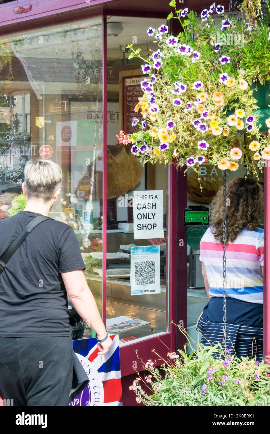 A sign in the window of a local baker's shop reads This is a Cash Shop Only. Stock Photo