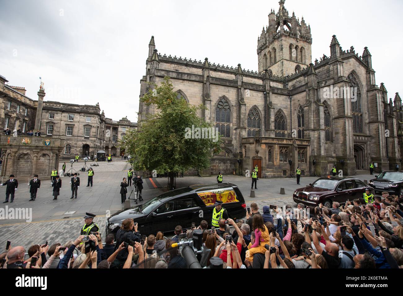 Edinburgh, Scotland, 11 September 2022.  The cortege carrying the coffin of Her Majesty Queen Elizabeth II drives down the Royal Mile High Street passing St Giles Cathedral, and the Mercat Cross, in Edinburgh, Scotland, 11 September 2022. Photo credit: Jeremy Sutton-Hibbert/ Alamy Live news. Stock Photo