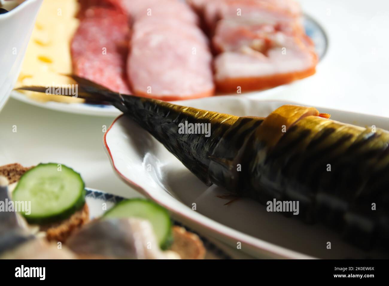 Defocus smoked mackerel. Smoked fish with spices on dark background on holiday table. Closeup. Fish bonito. Out of focus. Stock Photo