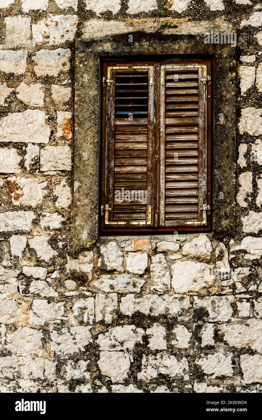 Detail of the stone wall and window with closed wooden shutters Stock ...