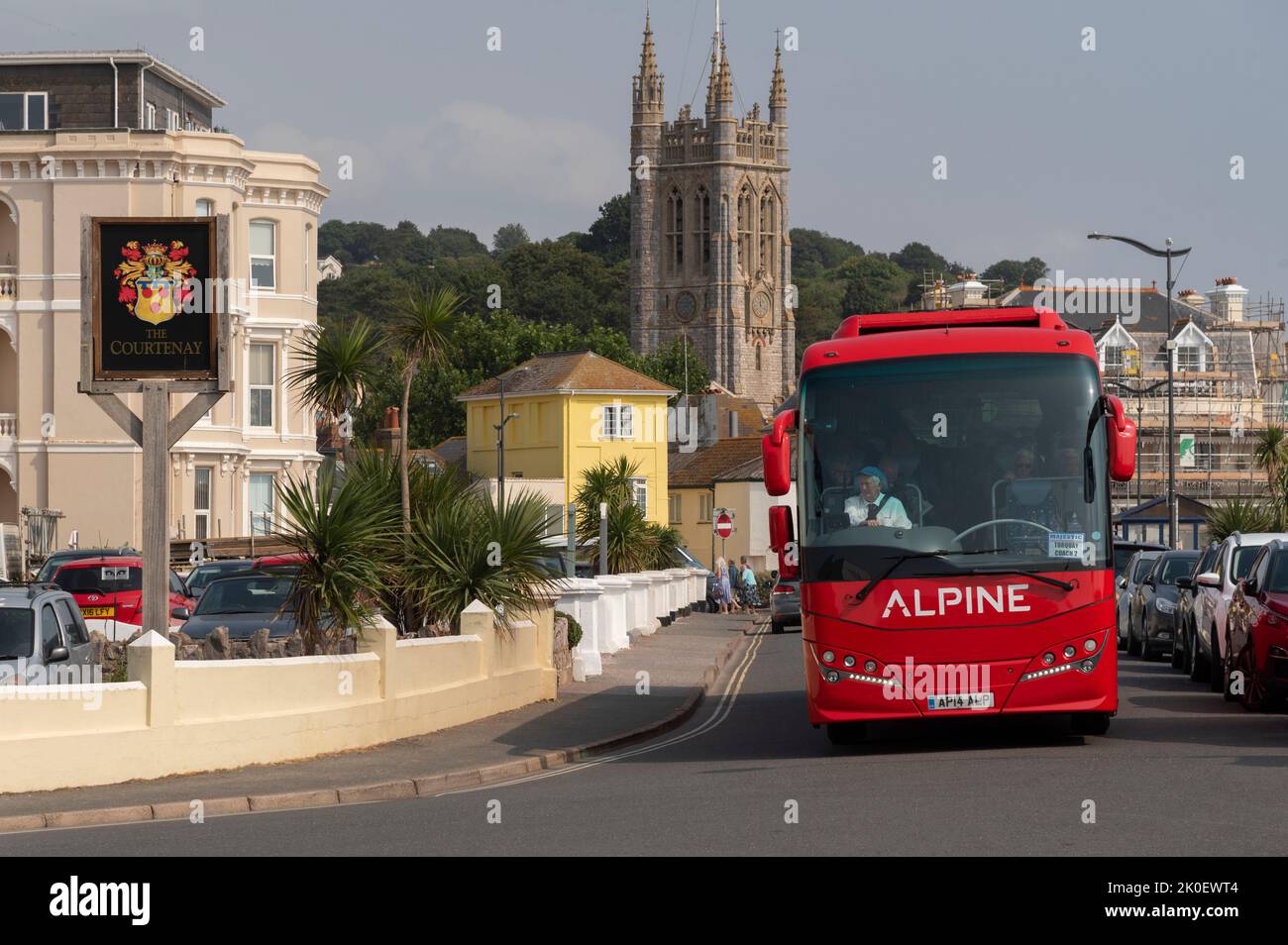 Teignmouth, Devon, England, UK. 2022.  Red touring coach driving through the seaside town of Teignmouth in south Devon, England, UK. Stock Photo