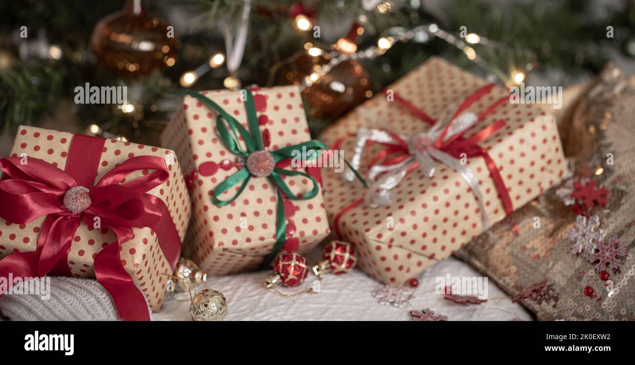 Festive gift boxes under the Christmas tree, close-up. Stock Photo
