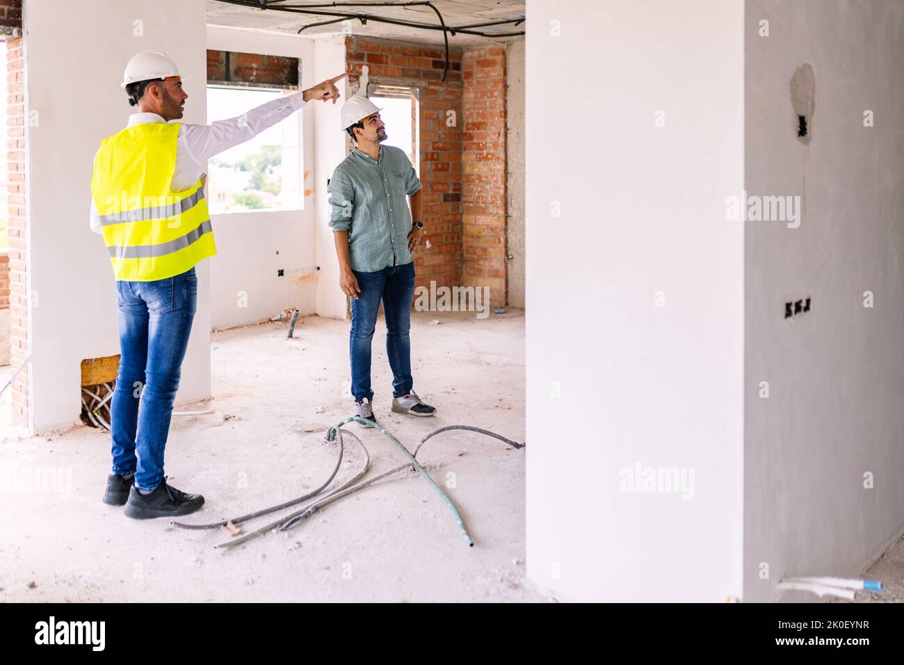 Construction engineer discussing with architect worker at indoor building site Stock Photo
