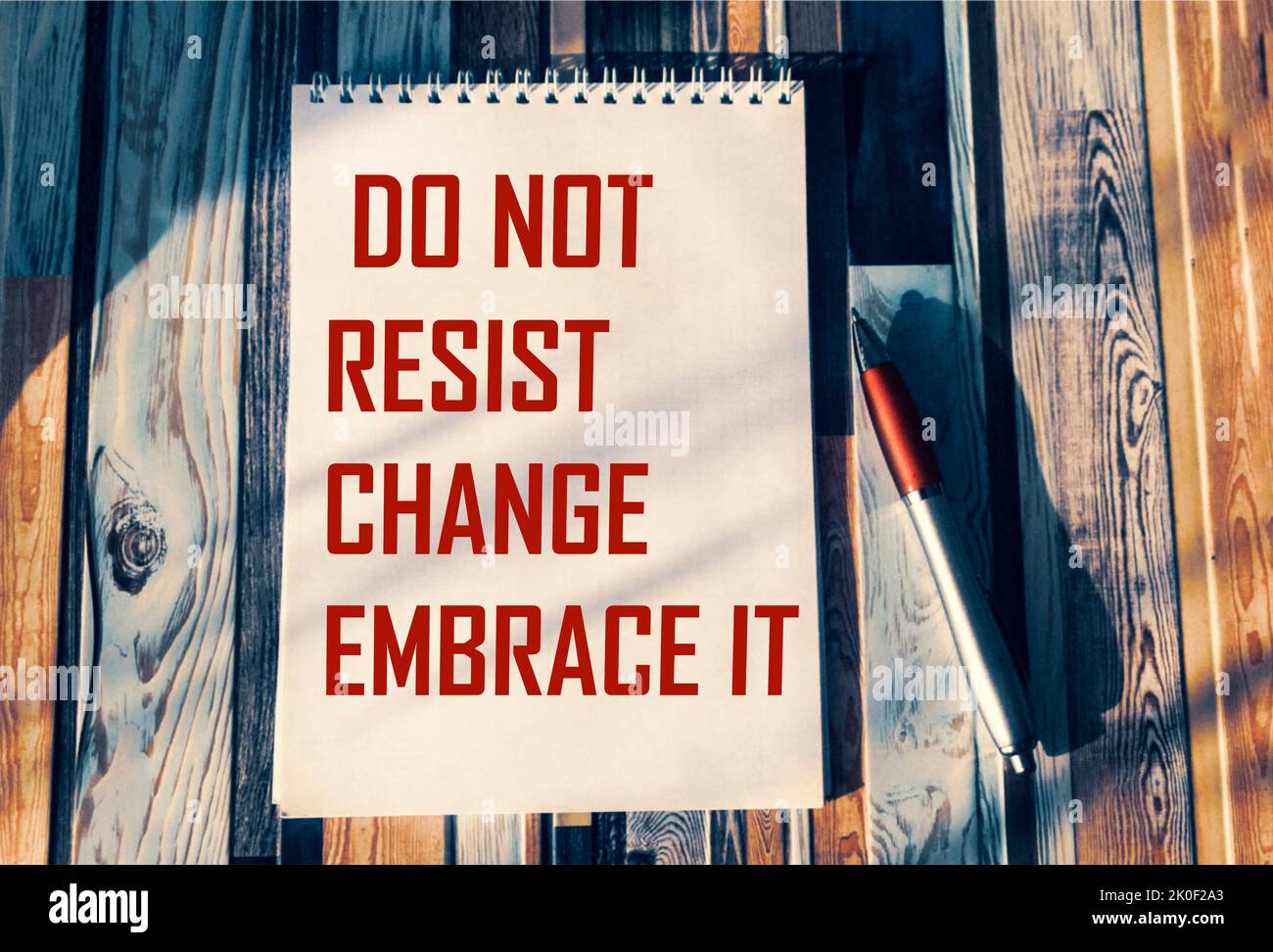 do not resist change, embrace it - motivational phrase on notepad with pen and vintage background Stock Photo