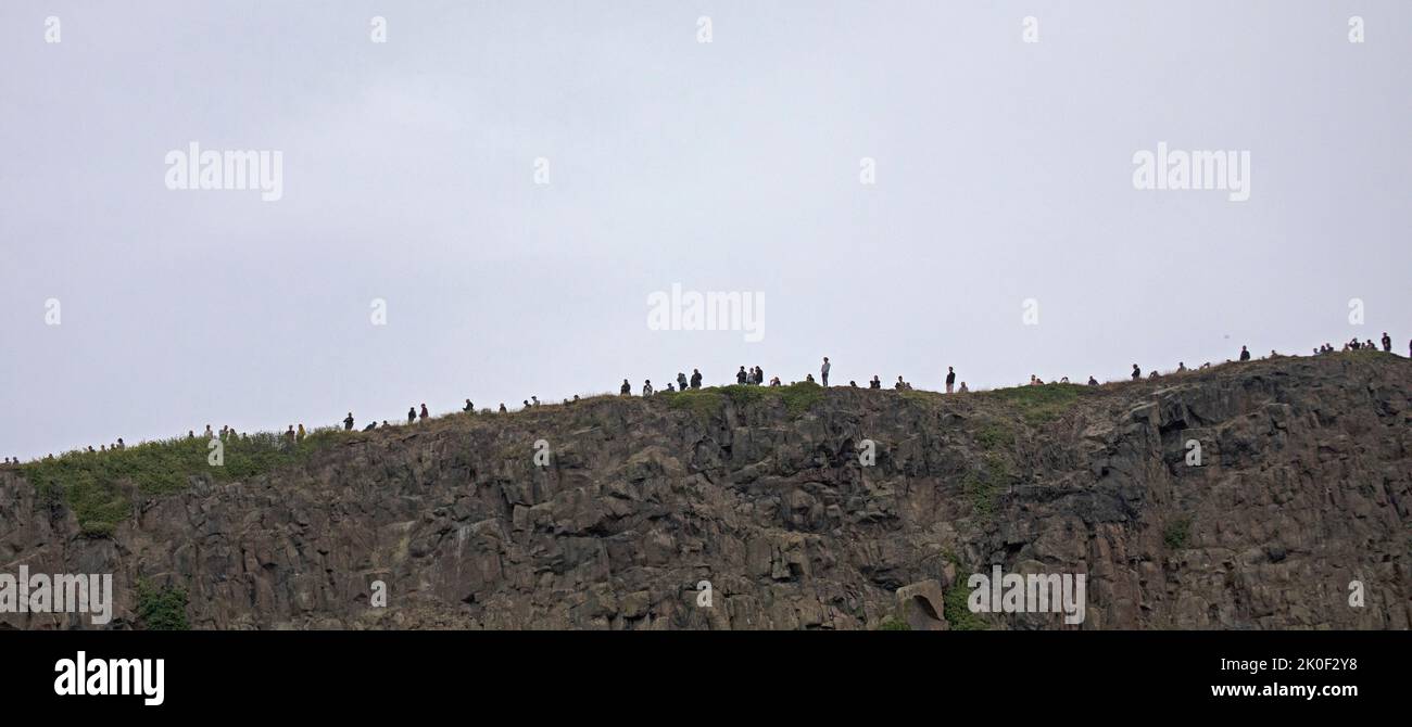 Edinburgh, Scotland, UK. 11th Sep, 2022. As Crowds gather to watch the hearse carrying the coffin of Queen Elizabeth II, draped with the Royal Standard of Scotland, passing down the Royal Mile, Edinburgh Scotland.others chose to climb above Salisbury Crags to view.  Credit: Arch White/alamy live news Credit: Arch White/Alamy Live News Stock Photo