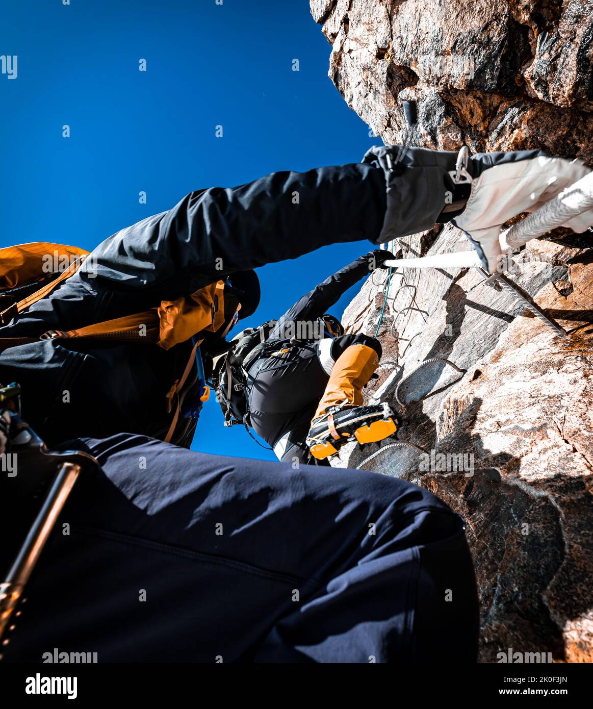 Two Mountaineers Climbing in the Alps with Alpine Equipment and Gloves Stock Photo
