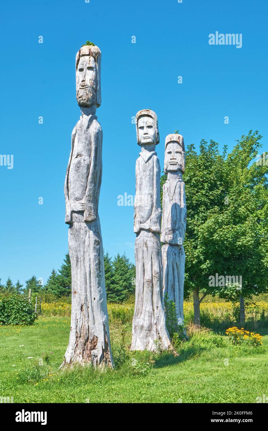 Three dead trees that were transformed into works of art when they were carved into human forms.  Located on Big Island Nova Scotia. Stock Photo