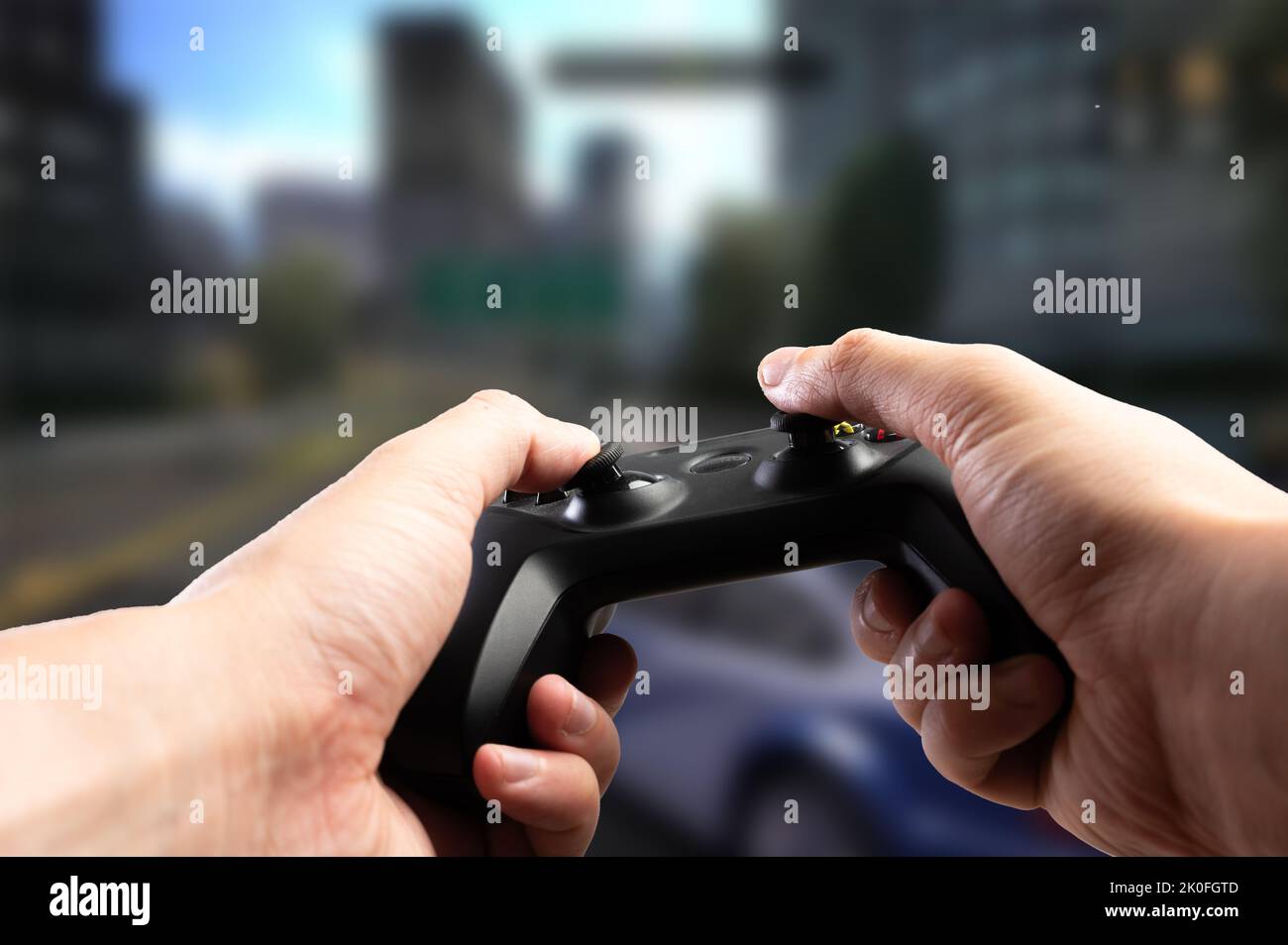 GAM22ICB joystick in the hands of a gamer against the backdrop of an exciting video game on the screen of a large plasma TV. Passion, fun pastime, onl Stock Photo