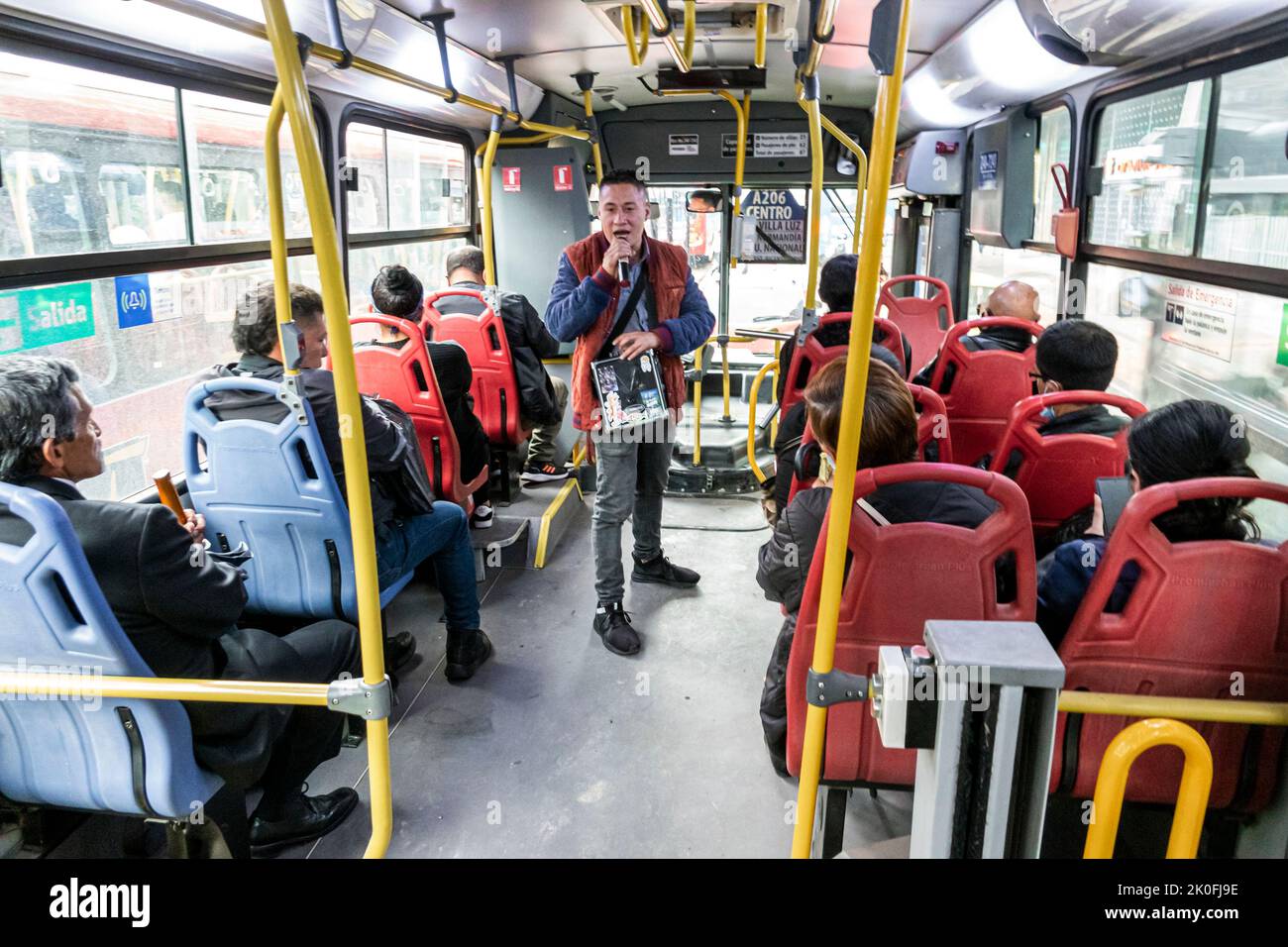 Bogota Coombia,riding Transmilenio bus route D206 Carrera 10,man men male woman women female,rider riders riding passenger passengers inside interior, Stock Photo