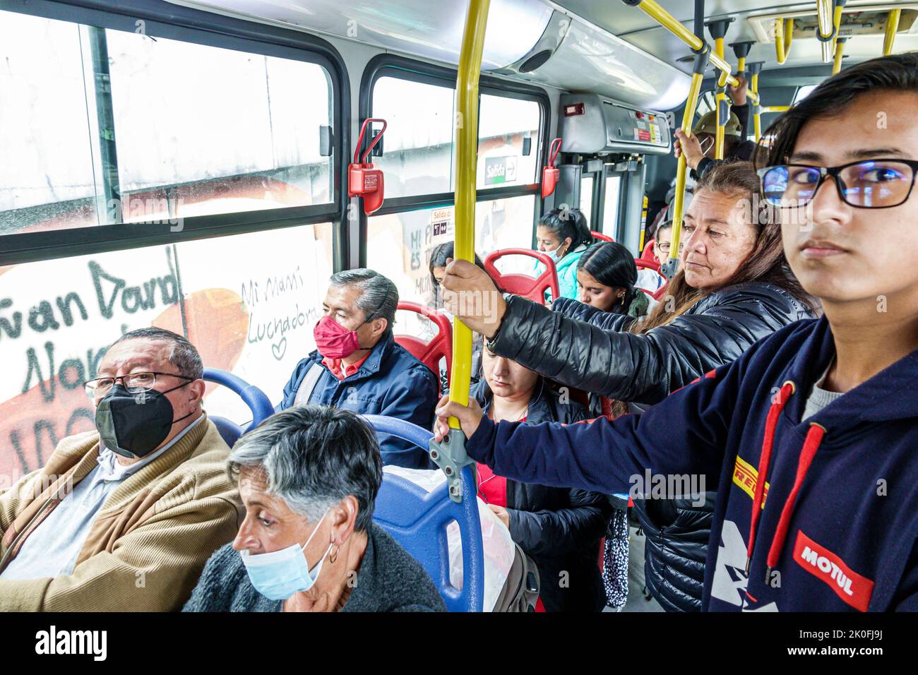 Bogota Coombia,riding Transmilenio bus route D206 Carrera 10,man men male woman women female,rider riders riding passenger passengers inside interior Stock Photo