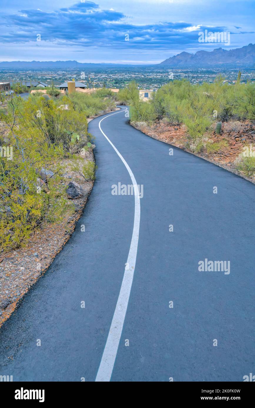 Asphalt downhill bike path and walking path heading to the residences
