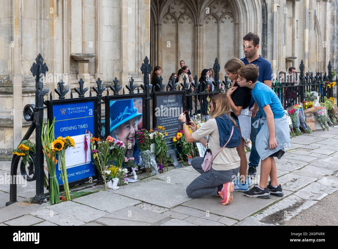 Winchester, Hampshire, UK. 11th September 2022. Following the death of Queen Elizabeth II on 8th September 2022, people have placed flowers and tributes in honour of Queen Elizabeth II outside the entrance to Winchester Cathedral. The country is in a period of national mourning until her funeral. Stock Photo