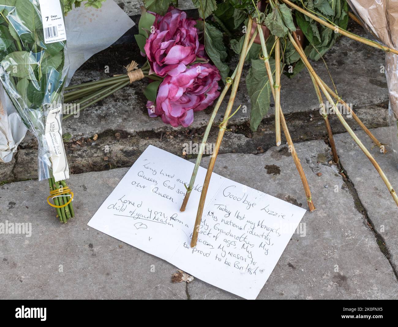 Winchester, Hampshire, UK. 11th September 2022. Following the death of Queen Elizabeth II on 8th September 2022, people have placed flowers and tributes in honour of Queen Elizabeth II outside the entrance to Winchester Cathedral. The country is in a period of national mourning until her funeral. Stock Photo