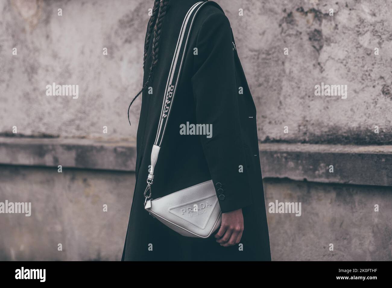 Milan, Italy - February, 24: Street style, woman wearing black coat and white Prada bag. Stock Photo