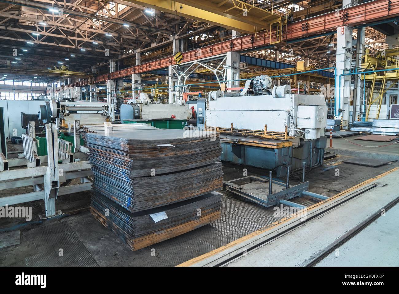 Factory for production of industrial equipment and machinery. Machine tools for working with iron and stack of metal sheets. Stock Photo