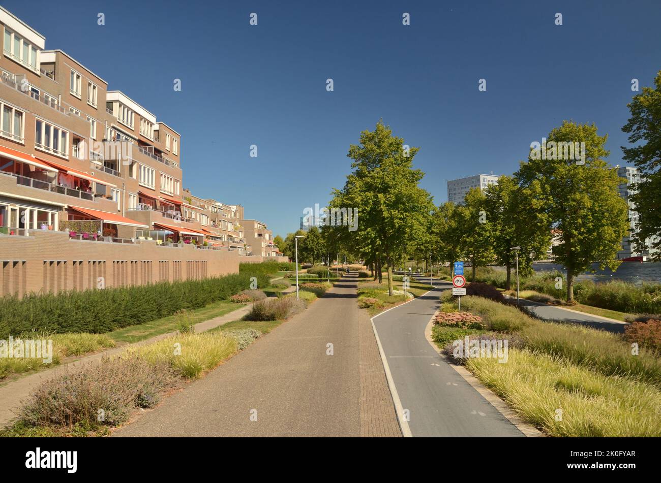 A green corridor with a segregated footway and cycle paths in a suburb of Almere, a planned town in the Netherlands Stock Photo