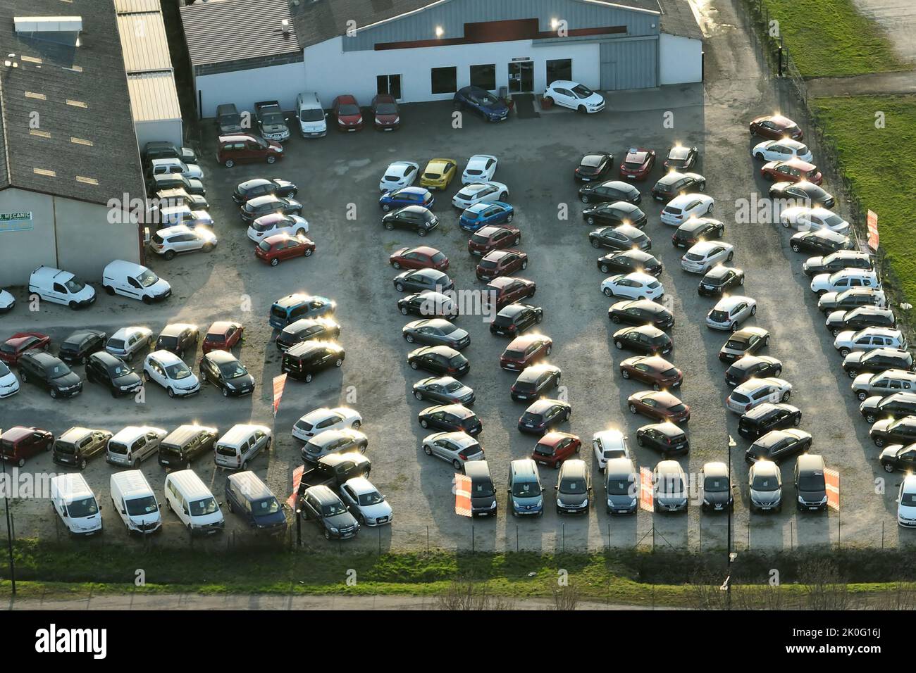 Aerial view of many colorful cars parked on dealer parking lot for sale