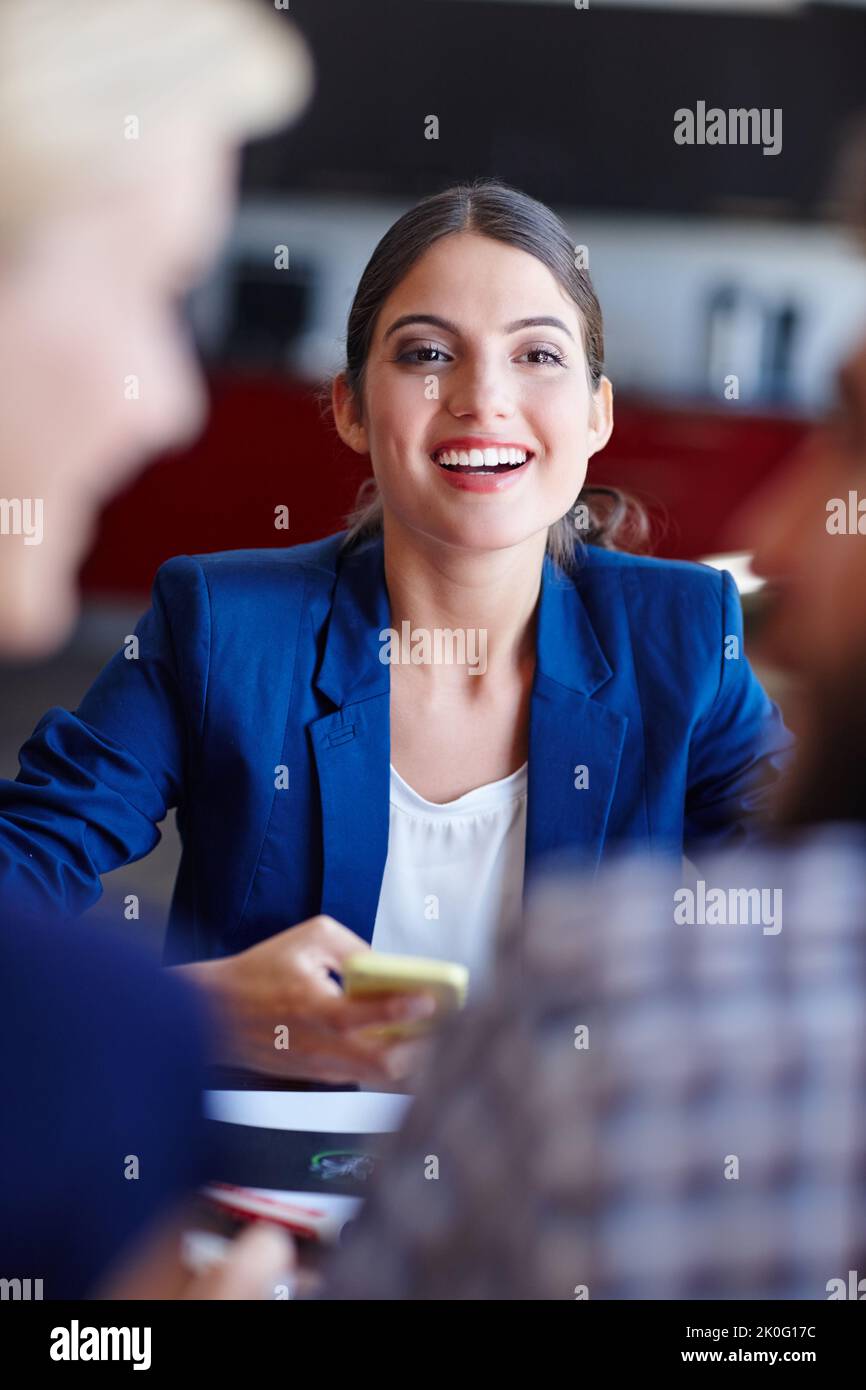 Shes an ambitious young professional. Portrait of a young creative professional in a meeting with her coworkers. Stock Photo