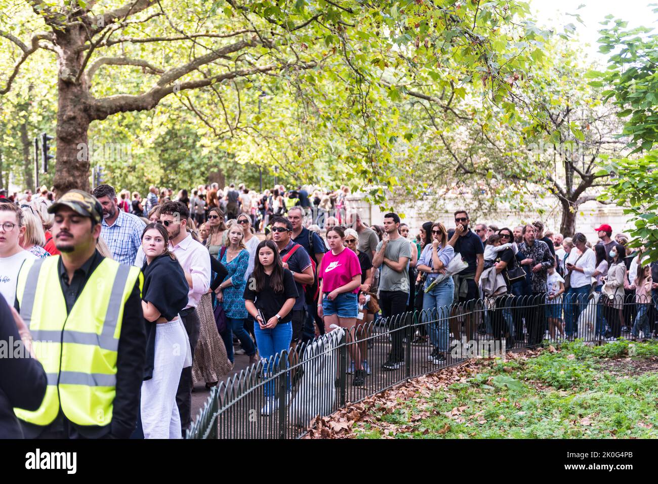 People waiting in long queue patiently to pay respect at Buckingham Palace Stock Photo