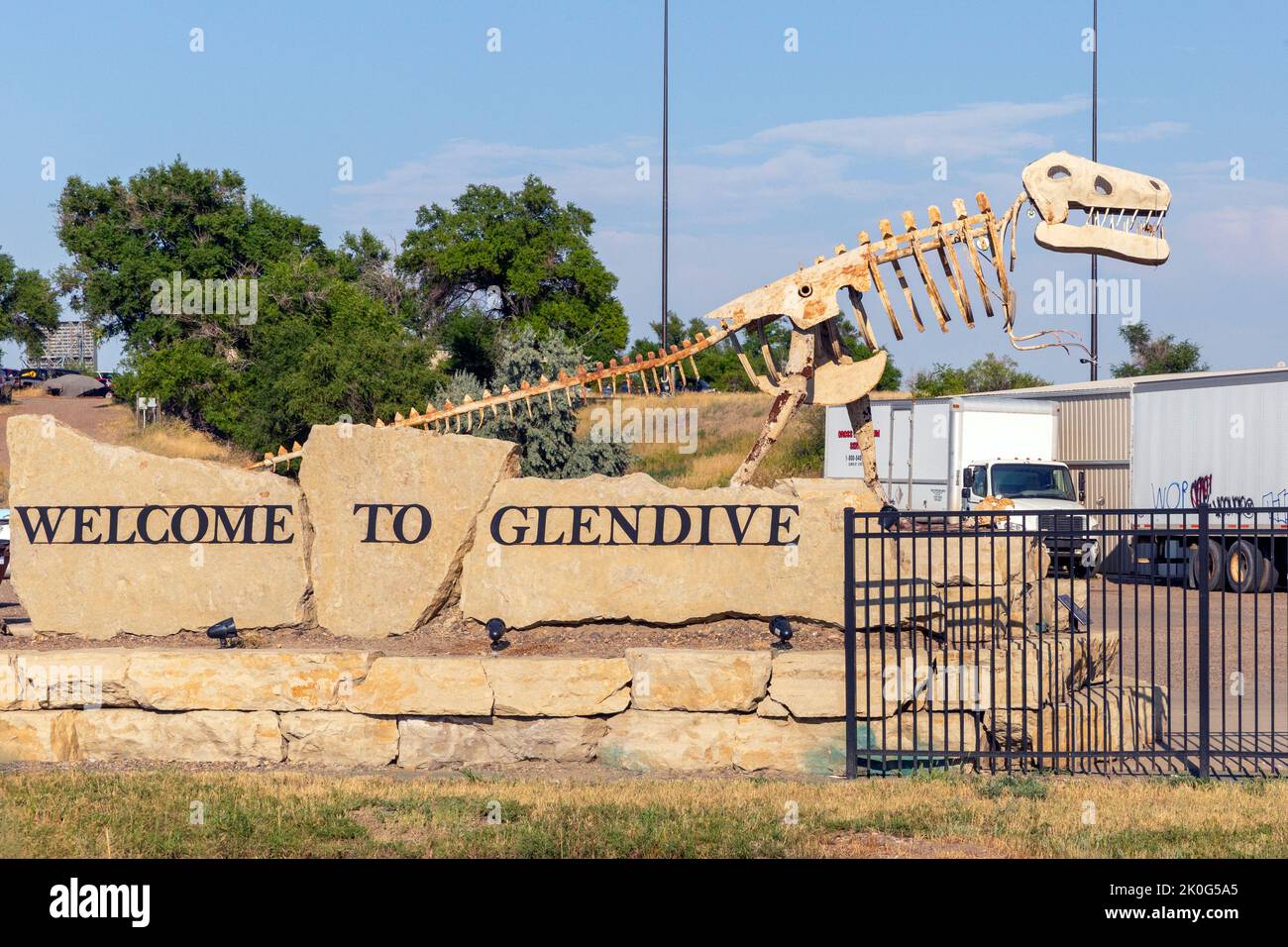 Roadside Welcome to Glendive sign with metal sculpture of a dinosaur in Glendive, Montana.  The sculptures is a tribute to the many dinosaurs bones fo Stock Photo