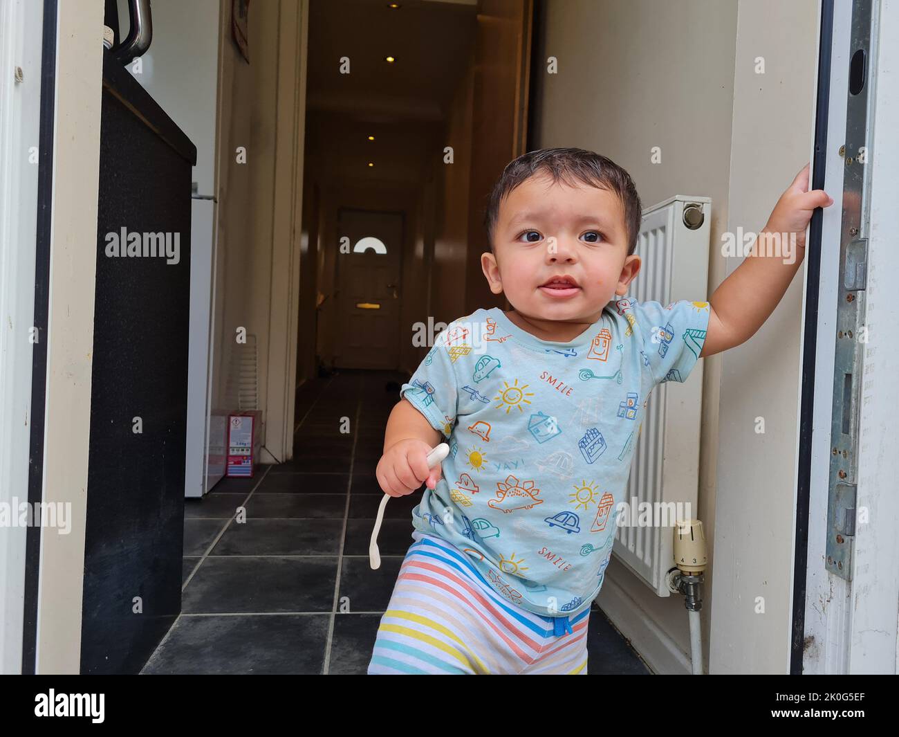1 Year old Cute Asian Pakistani Baby Boy standing at door Stock Photo