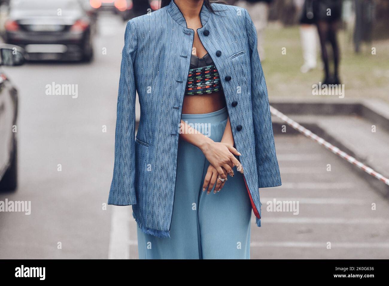 Milan, Italy - February, 24: Street style, woman wearing a blue striped print pattern with embroidered sequined oversized jacket, high waist pale blue Stock Photo