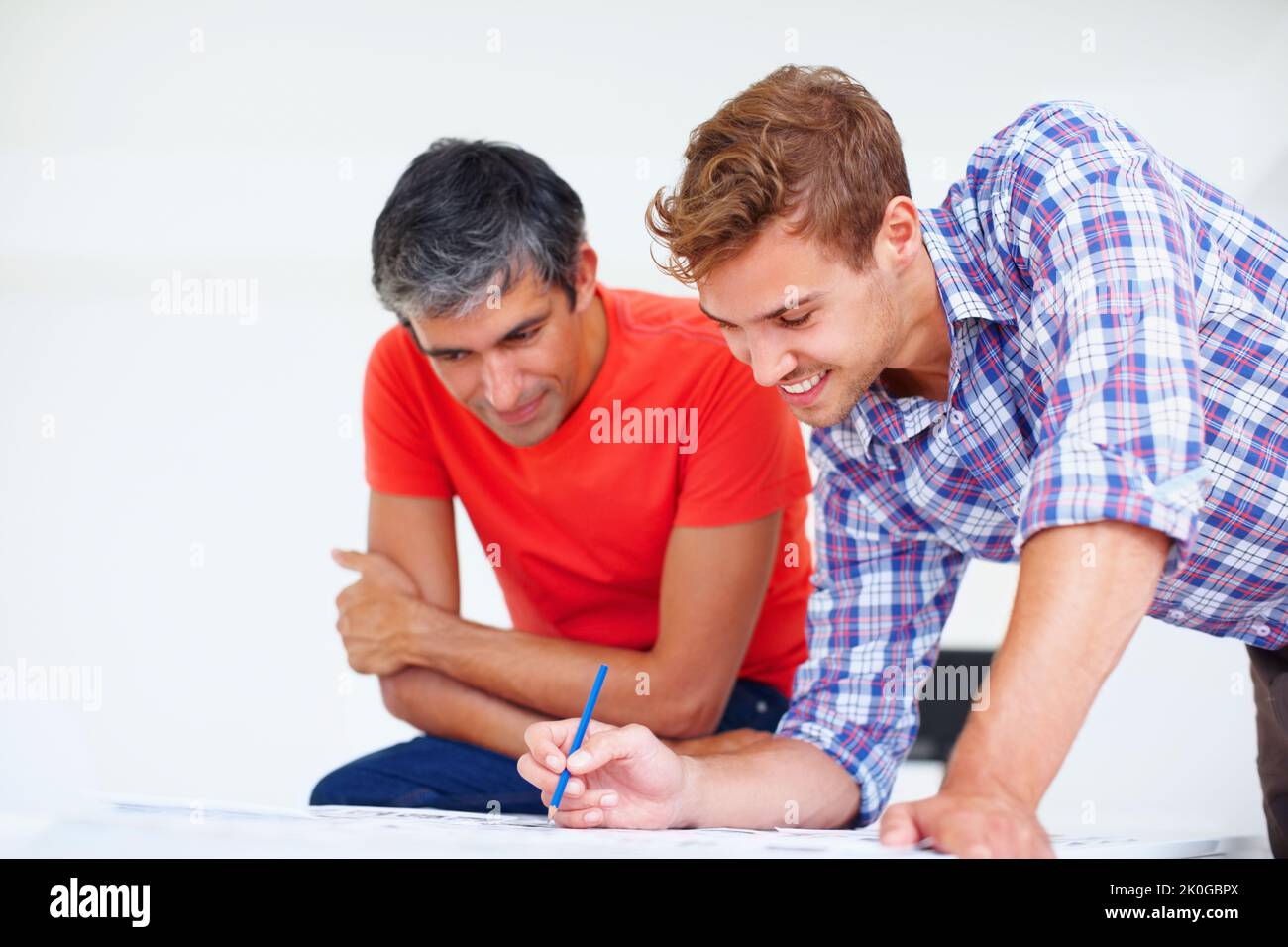 Photographers at work. Young professional photographer discussing with his colleague at work. Stock Photo